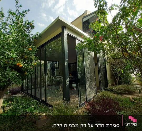 מבנה זכוכית עם מסגרות אלומיניום בגינה ירוקה